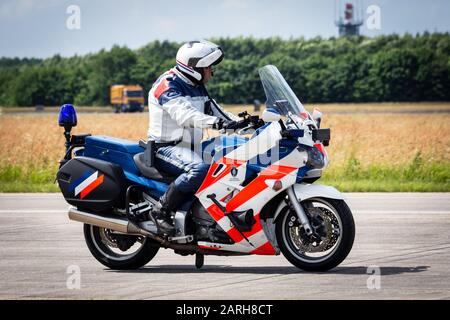 VOLKEL, NIEDERLANDE - Jun 15, 2013: Niederländischer Militärpolizist (Marechaussee) patrouilliert auf Motorrad beim niederländischen Luftwaffentag. Stockfoto