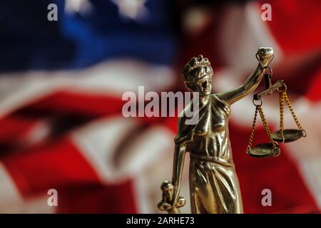 Recht und Gerechtigkeit in den Vereinigten Staaten von Amerika, Statue von Lady Gerechtigkeit mit USA-Flagge im Hintergrund, selektiver Fokus Stockfoto