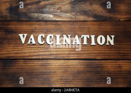 Impfkonzept. Beschriftung auf dunklem Holztischhintergrund. Vorbeugende Impfung gegen Viruserkrankungen. Stockfoto