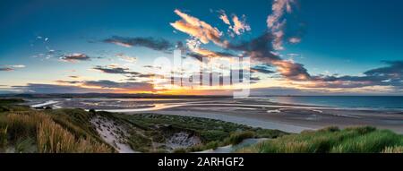 Sonnenuntergang über der Budle Bay mit Blick auf Lindisfarne in der Nähe von Bamburgh, Northumberland, England, Großbritannien Stockfoto