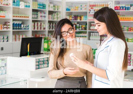 Zufriedener Kunde. Professionelle Beratung in der Apotheke. Selbstbewusster Apotheker berät einen Kunden über ein Produkt in der Apotheke Stockfoto