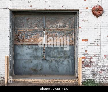 Garagentor an einem alten verlassenen Industriegebäude Stockfoto