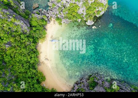 Tropische Insel auf dem Atoll und der türkisfarbenen Lagune. Felseninsel mit weißem Sandstrand, Luftbild. Caramoan-Inseln, Philippinen. Stockfoto