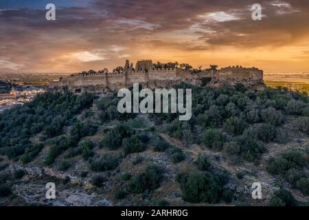 Luftaufnahme der mittelalterlichen Burg Corbera in Ruinen auf einem Hügel nahe der Küste mit Wänden und einem eigenständigen Turm in Spanien Stockfoto
