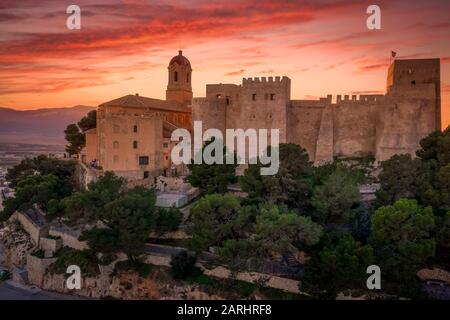Bei Sonnenuntergang bietet sich ein Panoramablick auf die Burg von Cullera und die beliebte Ferienstadt am Meer in der Nähe von Valencia Stockfoto