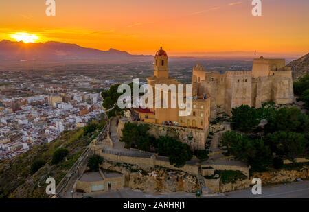 Bei Sonnenuntergang bietet sich ein Panoramablick auf die Burg von Cullera und die beliebte Ferienstadt am Meer in der Nähe von Valencia Stockfoto