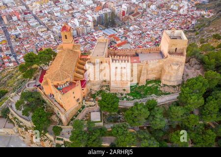 Bei Sonnenuntergang bietet sich ein Panoramablick auf die Burg von Cullera und die beliebte Ferienstadt am Meer in der Nähe von Valencia Stockfoto