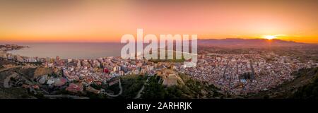 Bei Sonnenuntergang bietet sich ein Panoramablick auf die Burg von Cullera und die beliebte Ferienstadt am Meer in der Nähe von Valencia Stockfoto
