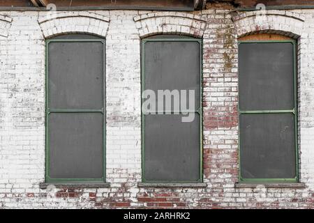 Drei Fenster auf einem alten verlassenen Industriegebäude Stockfoto