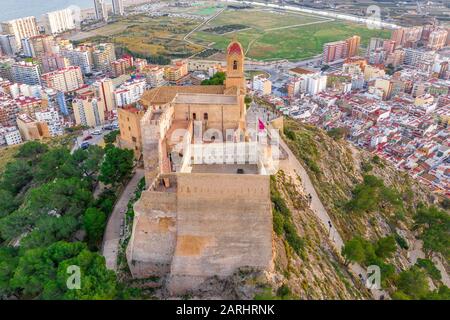 Bei Sonnenuntergang bietet sich ein Panoramablick auf die Burg von Cullera und die beliebte Ferienstadt am Meer in der Nähe von Valencia Stockfoto