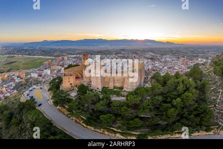 Bei Sonnenuntergang bietet sich ein Panoramablick auf die Burg von Cullera und die beliebte Ferienstadt am Meer in der Nähe von Valencia Stockfoto