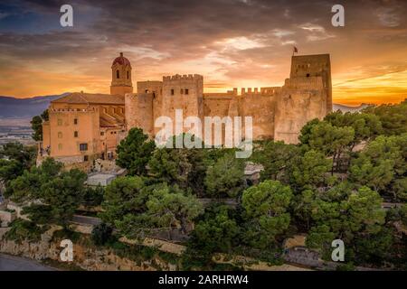 Bei Sonnenuntergang bietet sich ein Panoramablick auf die Burg von Cullera und die beliebte Ferienstadt am Meer in der Nähe von Valencia Stockfoto