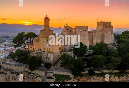Bei Sonnenuntergang bietet sich ein Panoramablick auf die Burg von Cullera und die beliebte Ferienstadt am Meer in der Nähe von Valencia Stockfoto