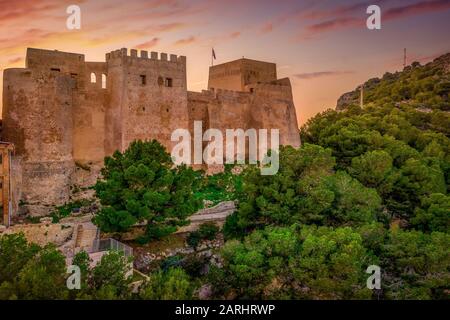 Bei Sonnenuntergang bietet sich ein Panoramablick auf die Burg von Cullera und die beliebte Ferienstadt am Meer in der Nähe von Valencia Stockfoto