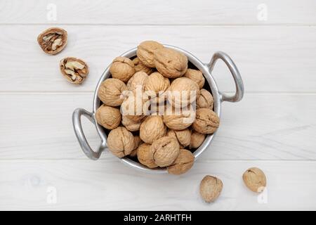 Walnüsse auf der Schüssel auf weißem Holztisch. Juglans regia Stockfoto