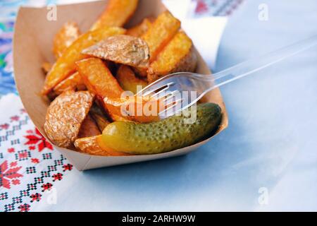 Kartoffeln mit eingepickter Gurke auf dem Lebensmittelmarkt. Ukrainische nationale Lebensmittel. Straßenküche und Kochkonzept für den Außenbereich. Stockfoto