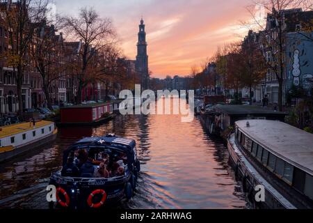 Abend über den wunderschönen Amsterdamer Grachten im Spätherbst. Fahrräder stehen an den Brücken im Vordergrund Stockfoto