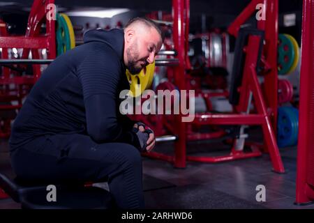 Bodybuilder ruht nach dem Training. Muskulöser Mann Ruht Nach Der Übung. Sport und Fitness. Fitness-Mann im Fitnessstudio. Stockfoto