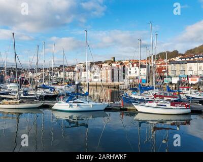 Yachts moored im Außenhafen am Scarborough Harbour mit Sandside hinter Scarborough North Yorkshire England Stockfoto