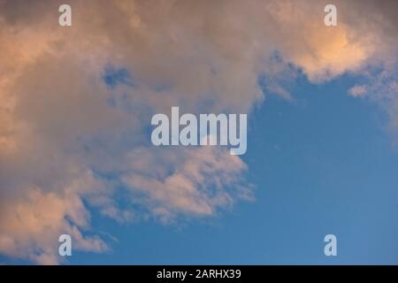 Schöne wispige Wolken am späten Nachmittag, die einen klaren blauen Himmel über dem Kopf zeigen Stockfoto