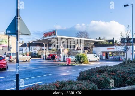 Sainsburys Tankstelle mit Fahrzeugen, die an einem sonnigen Winter am späten Nachmittag Schlange stehen Stockfoto