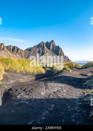 Epischer Luftdronblick an einem sonnigen Tag über die Landschaft des schwarzen Sandstrands in Stokksnes fliegen. Vestrahorn-Berg im Hintergrund. Natur und eg Stockfoto