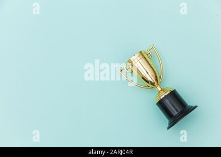 Einfach flach design Sieger oder Meister gold Trophäe Cup auf Blau Pastell bunten Hintergrund isoliert. Sieg den ersten Platz des Wettbewerbs. Sieg oder Erfolg Konzept. Ansicht von oben kopieren Raum Stockfoto