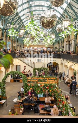 London/Großbritannien - 24. November 2019: Menschen, die in einem Café im Covent Garden Market sitzen, einer der beliebtesten Touristenattraktionen in London, Großbritannien Stockfoto