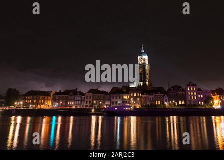 Blick auf den Fluss IJssel und die Marienkirche in Deventer, Niederlande bei Nacht Stockfoto