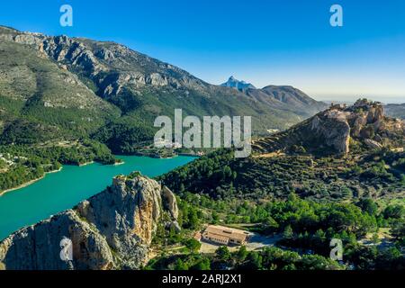 Luftaufnahme von El Castell de Guadalest und der Burg Benimantell in der Nähe von Alicante Spanien, einem beliebten Touristenziel in den Bergen über dem Wasserreservoir Stockfoto