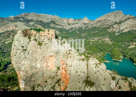 Luftaufnahme von El Castell de Guadalest und der Burg Benimantell in der Nähe von Alicante Spanien, einem beliebten Touristenziel in den Bergen über dem Wasserreservoir Stockfoto