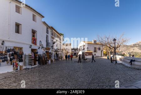 Panoramablick auf den Hauptplatz des beliebten spanischen Urlaubsziels El Castell de Guadalest mit Souvenirläden und Touristen Stockfoto
