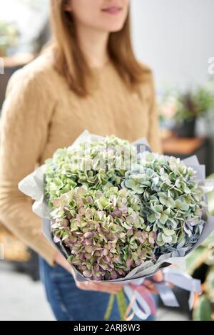 Blumenstrauß aus grüne Blume. Wunderschöne Hortensienblüten in womans Hände. Die Arbeit der Florist in einem Blumenladen. Frische Schnittblume. Stockfoto