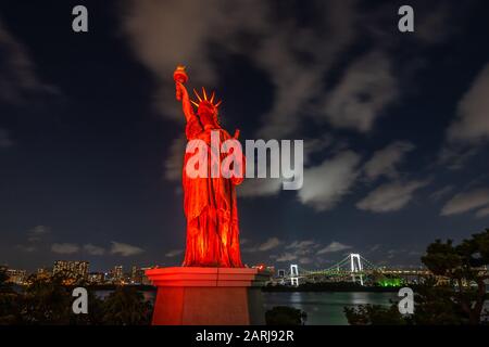 Nachtsicht auf Tokios Freiheitsstatue Replica und Rainbow Bridge auf dem Hintergrund auf Odaiba Island, Japan Stockfoto