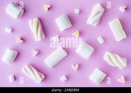 Flat lag mit verschiedenen Arten von Marshmallow und weicher Süßigkeiten auf pinkfarbenem Hintergrund Stockfoto