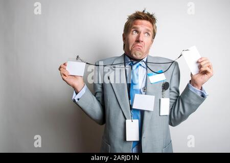 Verwirrte Büroangestellte, die mit leeren Namensschilder indatiert wurden, die ein lustiges Gesicht neben dem weißen Kopierbereich bilden Stockfoto