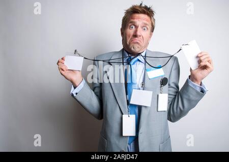 Verwirrte Büroangestellte, die mit leeren Namensschilder indatiert wurden, die ein lustiges Gesicht neben dem weißen Kopierbereich bilden Stockfoto