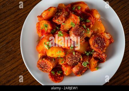 Kartoffeln eintauen mit Schweinewürstchen und Kräutern - Draufsicht Stockfoto
