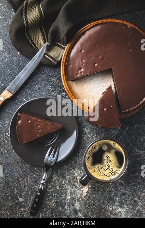 Schokoladenkuchen und Kaffeetasse auf dem alten Küchentisch. Stockfoto