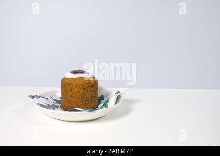 Runebergs Kuchen ist ein finnisches Gebäck, das mit Mandeln und Arrack oder Rum gewürzt ist. Es hat normalerweise Himbeerbenstau, der oben von einem Ring aus Eisbildung umkreist wird. Stockfoto