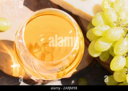 Bernsteinwein in Gläsern auf der Natur: Stillleben mit Käse, Trauben und Wein im rustikalen Stil. Georgischer Nationalwein oder italienischer Wein passito Stockfoto