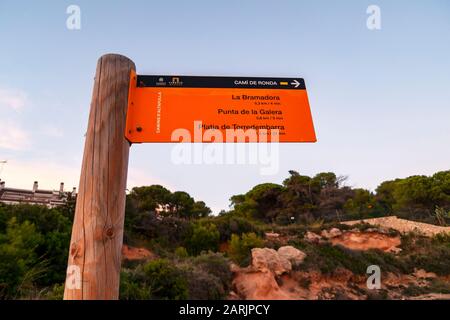 Eine Wegmarkierung in katalanischer Sprache zeigt die Entfernung zu La Bramadora, Punta de Galera und Platja de Torredembarra auf dem Cami de Ronda in Spanien. Stockfoto