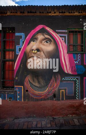 Dieses Gebiet ist bekannt als La Candelaria, einer der Hotspots von Bogota, wo es viele Wandbilder und Graffiti gibt. Wandgemälde von Carlos Trilleras, indigene Frau. Stockfoto