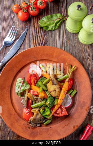 Vegetarische Küche, Beilage mit gebackenem Gemüse und Pilzen, Restaurantgericht, Vertikale Ausrichtung, Draufsicht Stockfoto