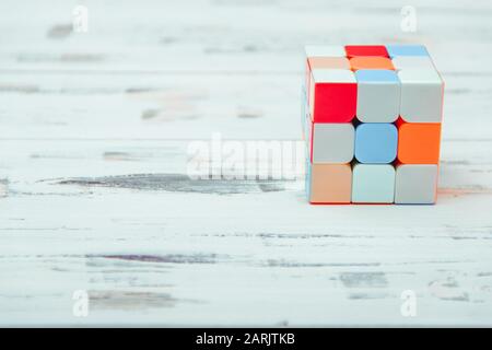 Rubik's Cube auf weißem Holzhintergrund. Intelligentes Spielkonzept. Freier Speicherplatz. Stockfoto