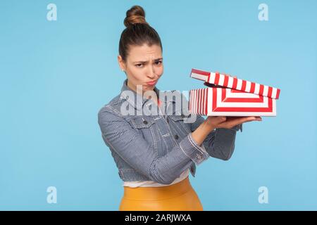 Schlechtes Geschenk. Verärgerte frustrierte Frau in der Denimjacke, die sich auspacken ließ, kleine Kartonschachtel öffnete und mit lustiger Enttäuschung die Kamera ansah Stockfoto