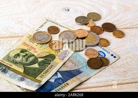 Bulgarische Lev Banknoten und Münzen auf einer weißen Holzoberfläche. Bulgarisches Papier und Metallgeld auf einem Tisch. Konzept für Wohlstand, Armut und Geld. Vorderansicht Stockfoto