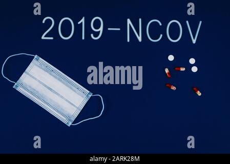 Das Wort 2019-ncov wurde mit weißen Buchstaben auf klassisch blauem Hintergrund mit dramatischem Licht gelegt. Roman-Coronavirus-Krankheit mit dem Namen 2019-nCoV . Pillen und Breat Stockfoto