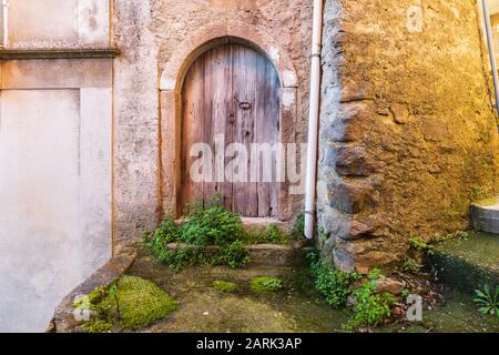 Italien, Sizilien, Provinz Messina, Novara di Sicilia. Eine verwitterte Bogentür in der mittelalterlichen Hügelstadt Francavilla di Sicilia. Stockfoto