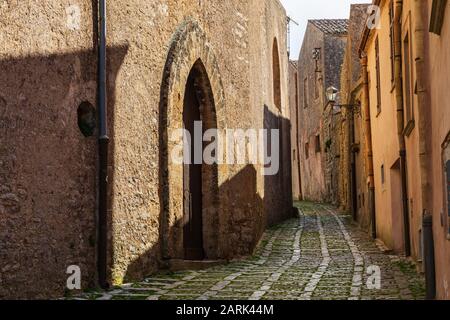 Italien, Sizilien, Provinz Trapani, Erice. Eine enge Kopfsteinpflasterstraße in der antiken Hügelstadt Erice. Stockfoto